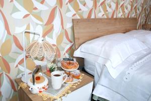 a bed with a tray of food on a night stand at Casa Politeama Spacious Central Flat by Oplonti Station for Pompeii, Sorrento and Naples in Torre Annunziata