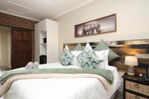 1 dormitorio con 1 cama blanca grande con almohadas en Hhusha Hhusha, en Malelane