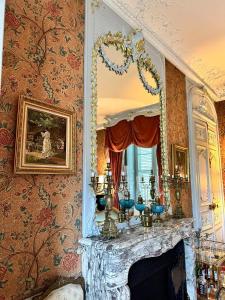 ein Wohnzimmer mit Kamin und Spiegel in der Unterkunft Chambre de Princesse avec Grande Salle de Bain in Blet