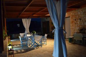 ハルキにあるVilla Romanza beach villaのテーブルと椅子、青いカーテンが備わる客室です。