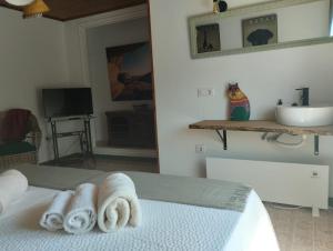 a bedroom with a sink and towels on a bed at Aloxamento A Mariña in Oia