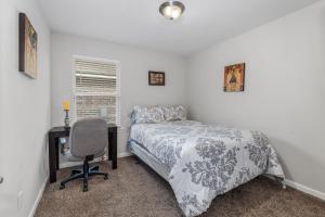 a bedroom with a bed and a desk and a chair at Spacious & Comfy KING Bed with Garage in Lake Charles in Lake Charles