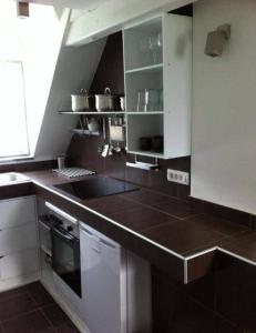 a kitchen with white cabinets and a black counter top at Apartments Podkoren 82 in Kranjska Gora