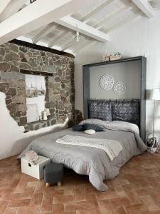a bedroom with a large bed with a stone wall at B&B Roseddu in Bitti