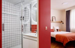 ein Bad mit einer Dusche, einem Bett und einem Waschbecken in der Unterkunft Hife Paris Issy in Issy-les-Moulineaux