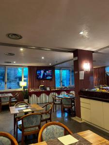 a restaurant with tables and chairs and a flat screen tv at Hotel Maja in Pescara