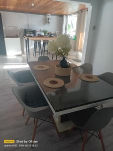 uma sala de jantar com mesa e cadeiras e uma cozinha em kaz'manou em Saint-Benoît