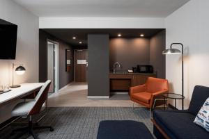 a living room with a couch and a kitchen at Courtyard by Marriott Cleveland in Cleveland