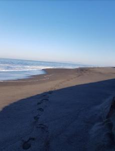 een paar voetafdrukken in het zand op een strand bij Depto con acceso a playa privada in San Pedro de la Paz