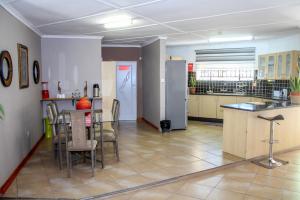 a kitchen and dining room with a table and a refrigerator at Thamalakane guest house in Maun