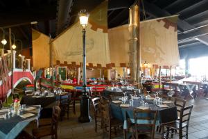 a dining room with tables and chairs and a lamp at Autohotel Venezia in Mirano