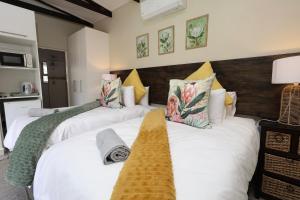 a bedroom with three beds with white sheets at Hhusha Hhusha in Malelane