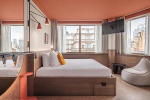 una camera d'albergo con letto e sedia di The Usual Brussels a Bruxelles