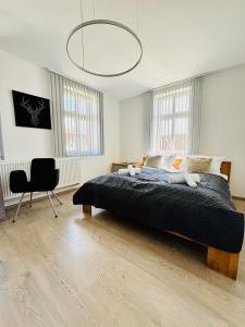 a bedroom with a large bed and a chair at SH-Apartments-Idylische FeWo Amenti, Wifi, Parken, zentral in Schmalkalden