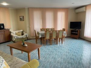 a living room with a table and chairs and a television at Villa Dechkoni in Kavarna