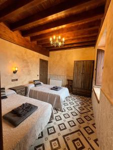 a hotel room with two beds and a chandelier at Casa Rural EL TORREÓN in Fontiveros