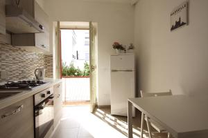 a kitchen with a white refrigerator and a table at Simona Beach Holiday House in Anzio +5 photos