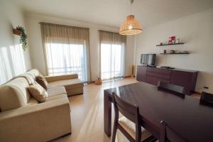 een woonkamer met een bank en een eettafel bij Dream House in Nazaré