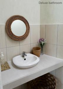 a white sink in a bathroom with a mirror at KAYA Uluwatu in Uluwatu