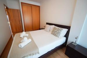 sypialnia z łóżkiem z dwoma ręcznikami w obiekcie Dream House w mieście Nazaré