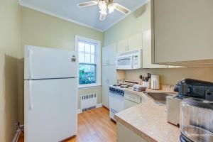 Il comprend une cuisine équipée d'appareils électroménagers blancs et d'un réfrigérateur blanc. dans l'établissement Historic Mamaroneck Guest House - Walk to Harbor!, 