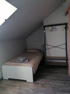 ein kleines Schlafzimmer mit einem Bett im Dachgeschoss in der Unterkunft MA SOLOGNE,ZOO BEAUVAL,CHATEAUX DE LA LOIRE,GOLF in Sassay