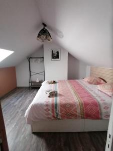 ein Schlafzimmer mit einem großen Bett im Dachgeschoss in der Unterkunft MA SOLOGNE,ZOO BEAUVAL,CHATEAUX DE LA LOIRE,GOLF in Sassay