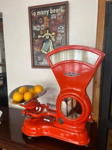 una tijera roja sentada en una mesa con un tazón de naranjas en Apart Hotel Español Coyhaique en Coyhaique