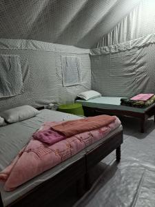 a room with two beds and a table in a tent at Hill dew homestay in Uttarkāshi
