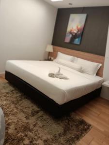 - une chambre avec un grand lit et des draps blancs dans l'établissement Royal Suite, à Kuala Lumpur