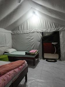 UttarkāshiにあるHill dew homestayのテント付きの客室で、ベッド2台が備わります。