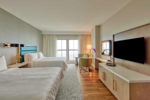 デスティンにあるHotel Effie Sandestin Resort, Autograph Collectionのベッド2台、薄型テレビが備わるホテルルームです。