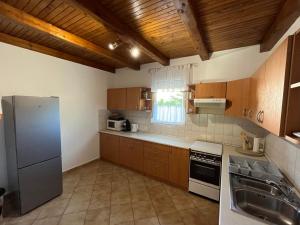 a kitchen with wooden cabinets and a stainless steel refrigerator at R-Home Apartman in Zamárdi
