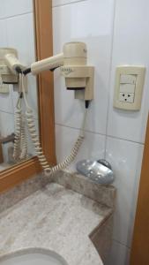 a bathroom with a phone on the wall next to a toilet at Hotel Guarulhos Slaviero Apto1808 in Guarulhos +19 photos