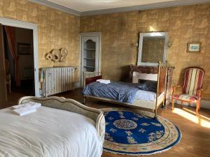 a bedroom with two beds and a chair at Chambre pour 3 personnes au Chateau in Blet