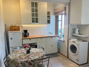 a kitchen with a table and a washing machine at Papli Apartment near the Beach in Pärnu
