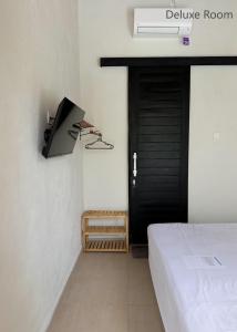 a bedroom with a bed and a black door at KAYA Uluwatu in Uluwatu