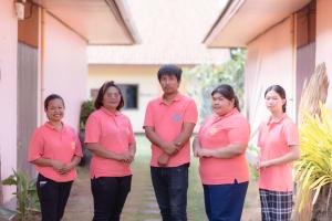 a group of people in pink shirts standing outside a house at NaLinNaa Resort Buriram ณลิ์ณน่า รีสอร์ท บุรีรัมย์ in Buriram