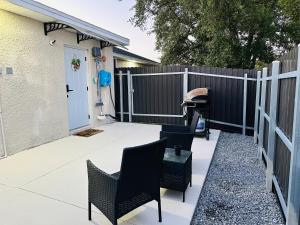 a backyard patio with chairs and a fence at Magnolias Suite in Lehigh Acres