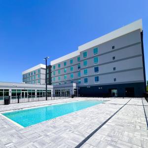 a building with a swimming pool in front of a building at Home2 Suites By Hilton Fort Walton Beach in Fort Walton Beach
