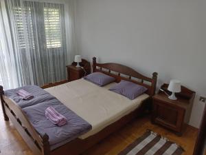 ein Schlafzimmer mit einem Bett mit lila Kissen darauf in der Unterkunft Vila Zeković in Donji Milanovac