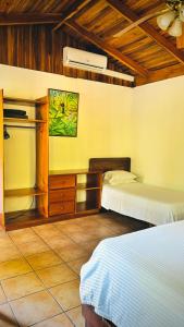 sypialnia z 2 łóżkami i sufitem w obiekcie Mal Pais Surf Camp w mieście Playa Santa Teresa