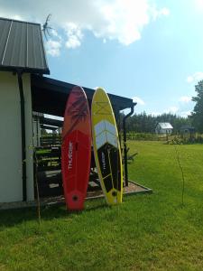 two surfboards are standing next to a building at Domek letniskowy na Kaszubach, Borowy Młyn, jezioro Gwiazda in Borowy Młyn