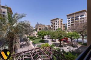 a view of a park with palm trees and buildings at Vogue - The Greens and Views in Dubai
