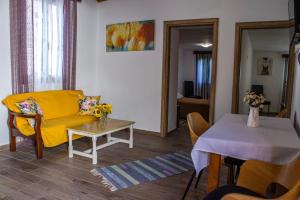 a living room with a yellow couch and a table at mamas eydokias house old town in Rhodes Town