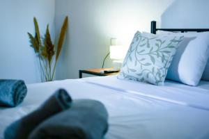 a bedroom with a white bed with a pillow at Petralia's Guest House in Skiathos