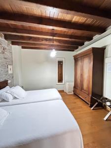 a bedroom with two beds and a wooden ceiling at Hotel Casa Soto in Vegadeo