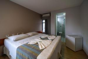 a bedroom with a bed with towels on it at Lagoa Park Hotel in João Pessoa