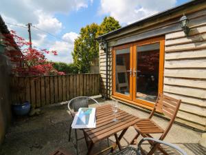 a wooden table and chair in front of a cabin at Yr Hen Ysgubor in Carmarthen