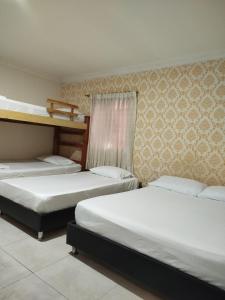 a room with three beds in a room at Hotel Kasvel in Valledupar